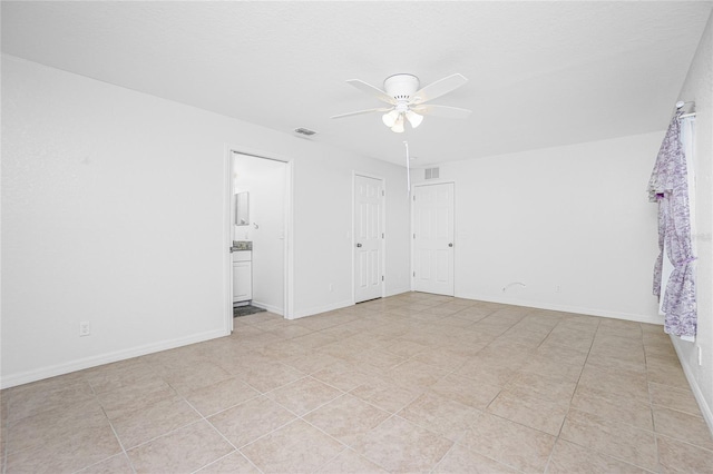 tiled spare room featuring ceiling fan