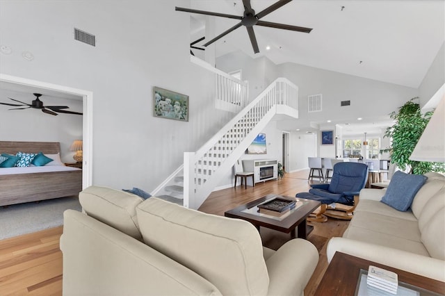 living room with ceiling fan, high vaulted ceiling, and hardwood / wood-style floors