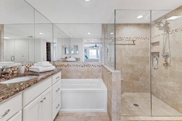 bathroom with separate shower and tub, ceiling fan, and vanity