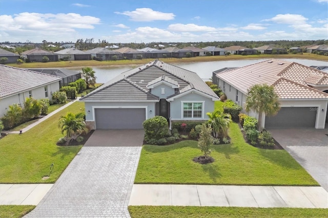 view of front of house with a water view, a front yard, and a garage