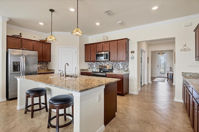 kitchen featuring appliances with stainless steel finishes, an island with sink, crown molding, and sink