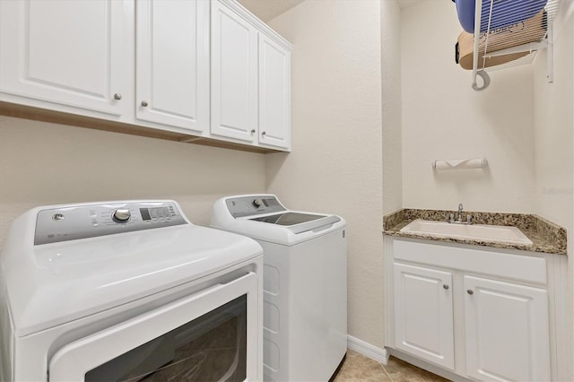 clothes washing area featuring cabinets, washing machine and dryer, light tile patterned floors, and sink