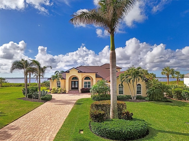 mediterranean / spanish home with a front yard