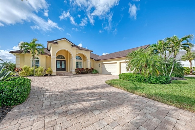 mediterranean / spanish home with a garage and a front lawn