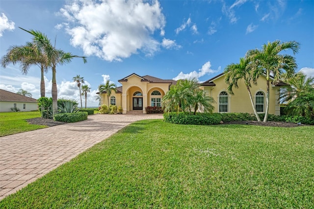 mediterranean / spanish home featuring a front yard