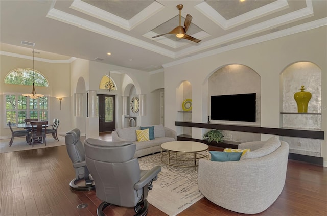 living room featuring ceiling fan, coffered ceiling, built in features, crown molding, and a towering ceiling