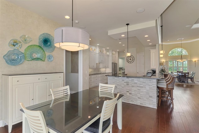 dining space with dark hardwood / wood-style flooring, ornamental molding, and sink