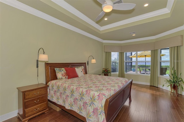 bedroom with a raised ceiling, dark hardwood / wood-style flooring, ceiling fan, and crown molding