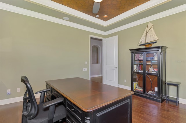 office space with a tray ceiling, crown molding, ceiling fan, and dark wood-type flooring