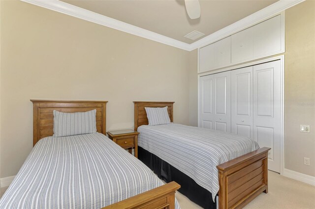 carpeted bedroom featuring ceiling fan, a closet, and ornamental molding