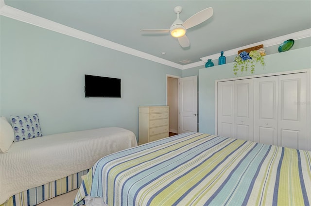 bedroom with ceiling fan, a closet, carpet floors, and crown molding