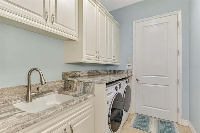 washroom featuring washer and dryer, cabinets, light tile patterned floors, and sink