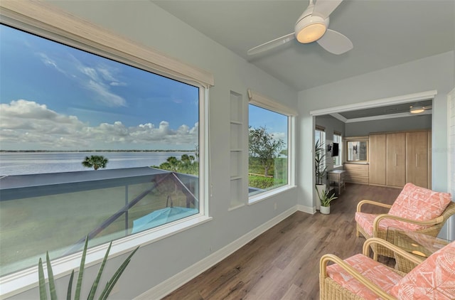 sunroom / solarium with a water view and ceiling fan