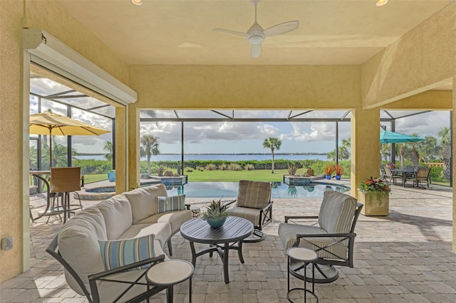 view of patio / terrace with a lanai, outdoor lounge area, ceiling fan, and a water view