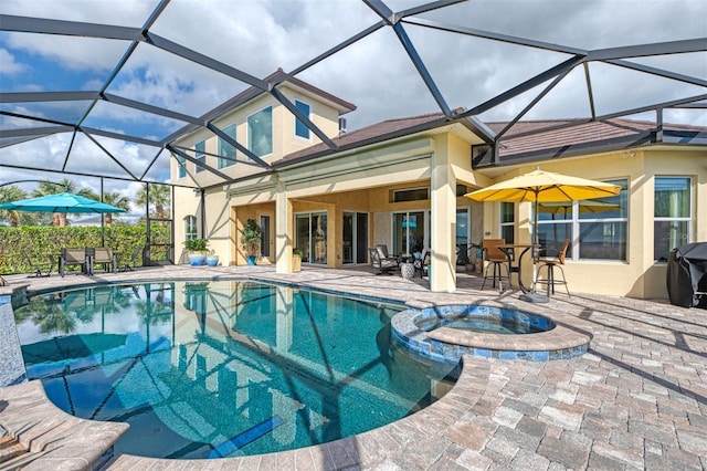 view of pool with an in ground hot tub, a patio area, and a lanai