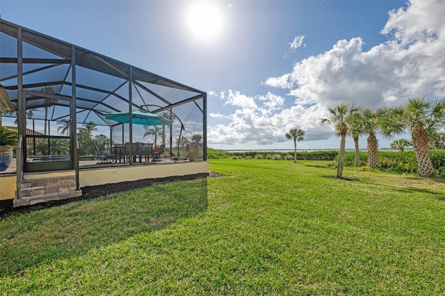 view of yard with glass enclosure and a patio area