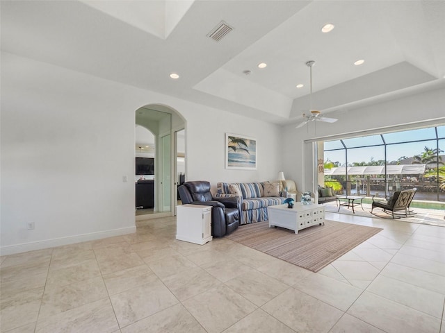 9567 Honeymoon Dr, Port Charlotte, FL 33981 - living room featuring a raised ceiling, arched walkways, a ceiling fan, recessed lighting, and light tile patterned floors