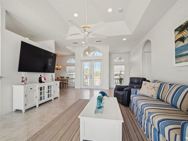 living room with french doors and ceiling fan with notable chandelier