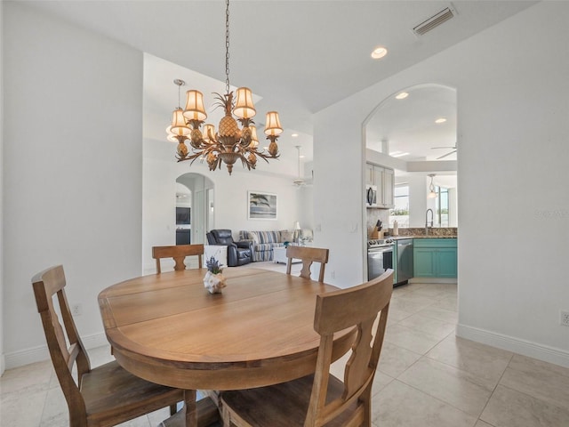 9567 Honeymoon Dr, Port Charlotte, FL 33981 - dining area with arched walkways, light tile patterned flooring, a chandelier, and recessed lighting
