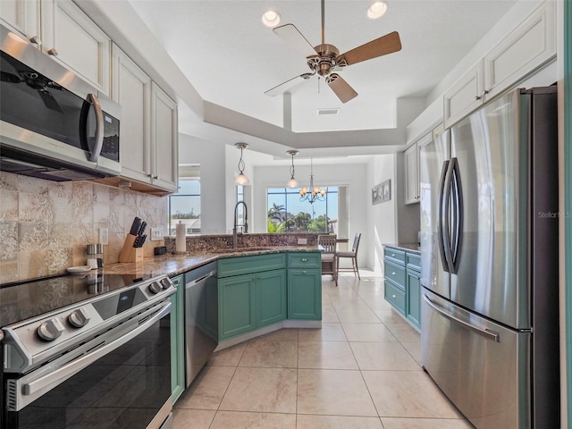 9567 Honeymoon Dr, Port Charlotte, FL 33981 - kitchen featuring appliances with stainless steel finishes, tasteful backsplash, a peninsula, ceiling fan, and white cabinets