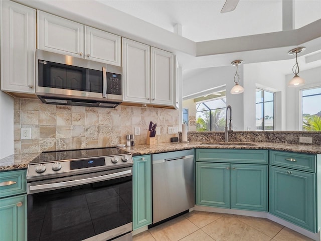 9567 Honeymoon Dr, Port Charlotte, FL 33981 - kitchen featuring appliances with stainless steel finishes, white cabinets, light tile patterned floors, decorative backsplash, and stone counters