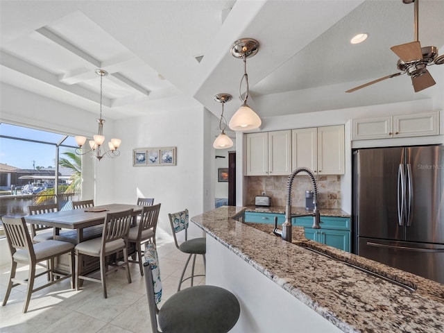 9567 Honeymoon Dr, Port Charlotte, FL 33981 - kitchen with freestanding refrigerator, backsplash, stone countertops, a ceiling fan, and light tile patterned floors