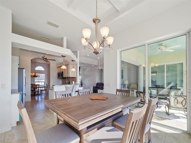 tiled dining room featuring sink and ceiling fan with notable chandelier