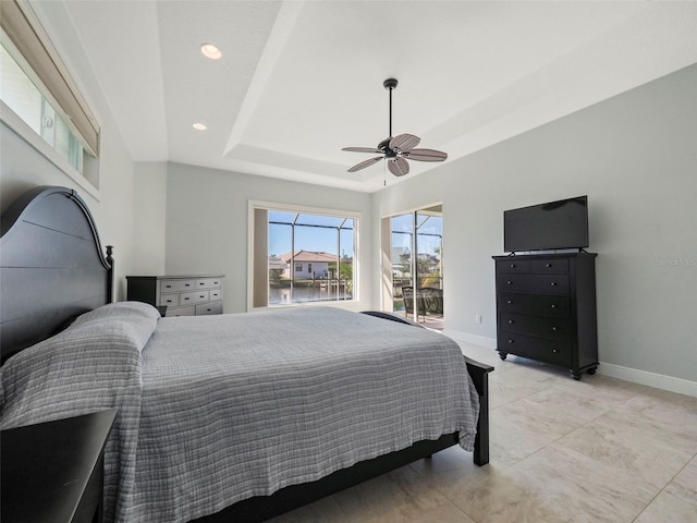 bedroom with ceiling fan and a tray ceiling