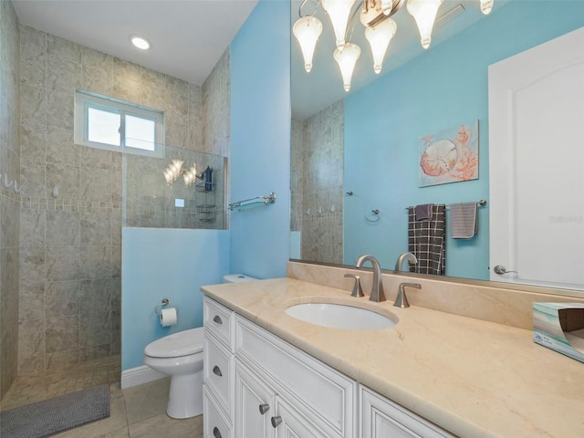 bathroom with tile patterned floors, vanity, a tile shower, and toilet