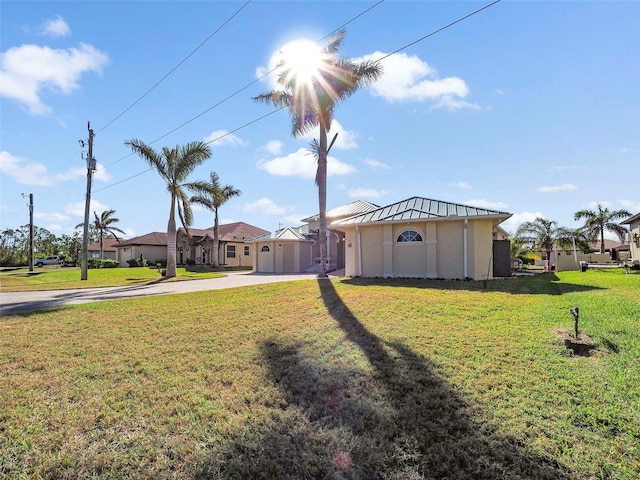 9567 Honeymoon Dr, Port Charlotte, FL 33981 - view of front of house featuring concrete driveway, a front yard, a standing seam roof, and a metal roof