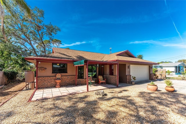 ranch-style house with a garage and a patio area