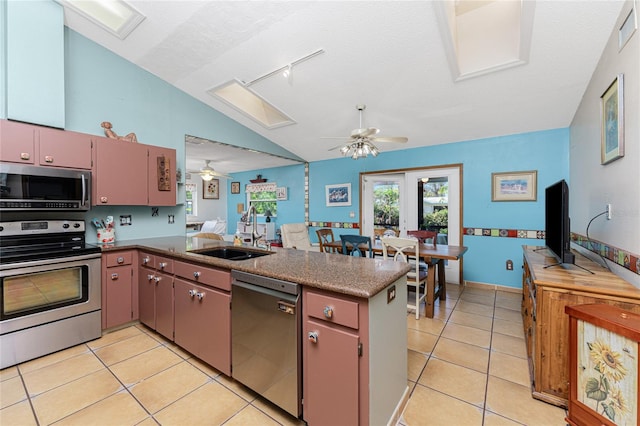 kitchen featuring kitchen peninsula, appliances with stainless steel finishes, light tile patterned floors, and sink