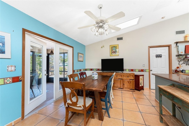 tiled dining area with ceiling fan, lofted ceiling, and french doors