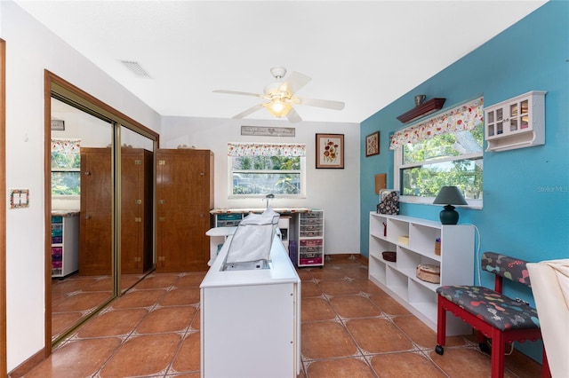 laundry room featuring ceiling fan and dark tile patterned floors