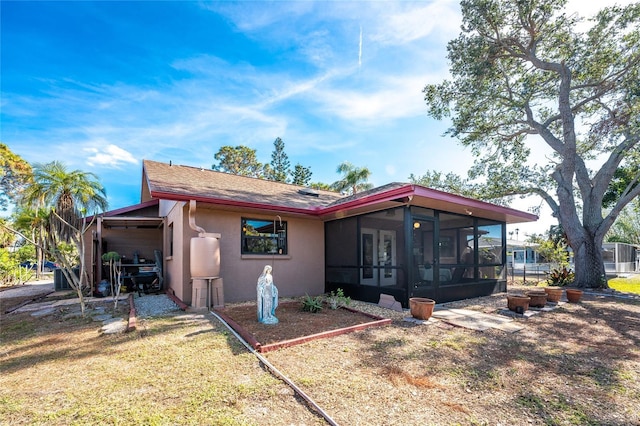 rear view of property with a sunroom and a lawn