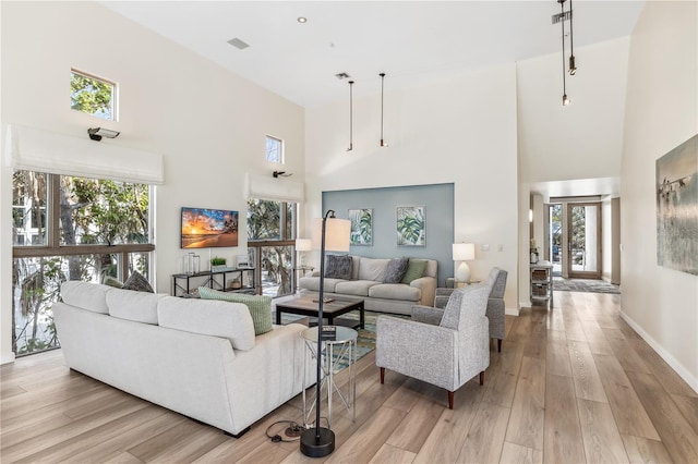 living room with light hardwood / wood-style floors and a high ceiling