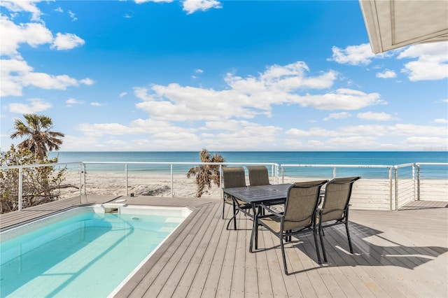 view of pool featuring a water view and a beach view