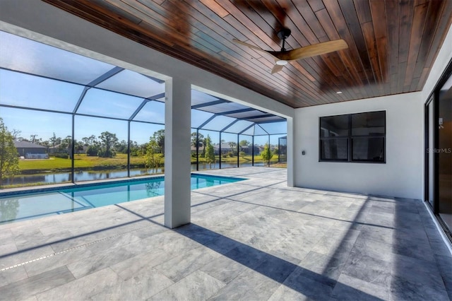 view of swimming pool featuring a lanai, ceiling fan, a patio area, and a water view