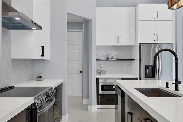 kitchen featuring white cabinets, sink, wall chimney exhaust hood, and appliances with stainless steel finishes