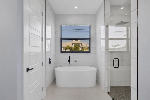 bathroom featuring independent shower and bath and tile walls