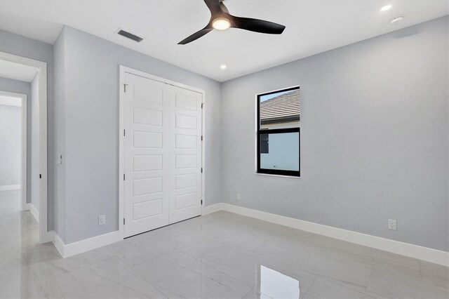 unfurnished bedroom featuring ceiling fan and a closet