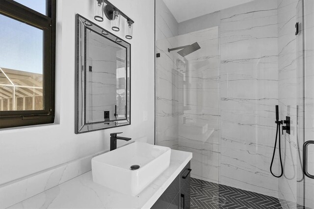 bathroom with a shower with door and sink