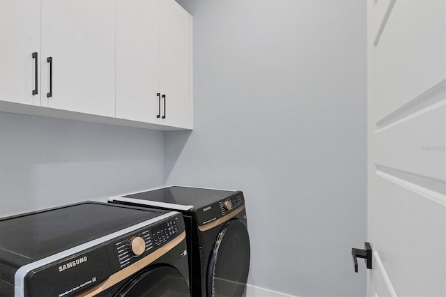 laundry room featuring cabinets and washing machine and clothes dryer