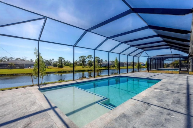 view of pool with glass enclosure, a patio area, and a water view