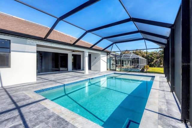 view of swimming pool featuring a lanai, ceiling fan, and a patio area