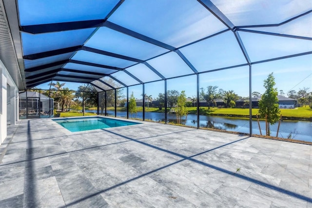 view of pool featuring glass enclosure, a patio area, and a water view