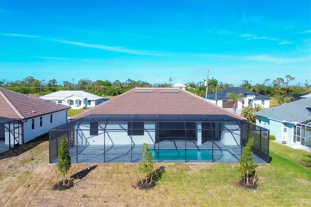 rear view of property featuring a yard and a lanai