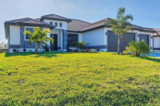 view of front of home with a front yard and a garage