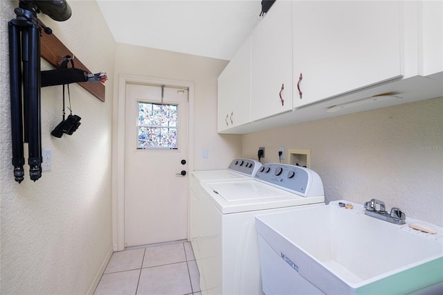 clothes washing area with light tile patterned flooring, cabinets, independent washer and dryer, and sink