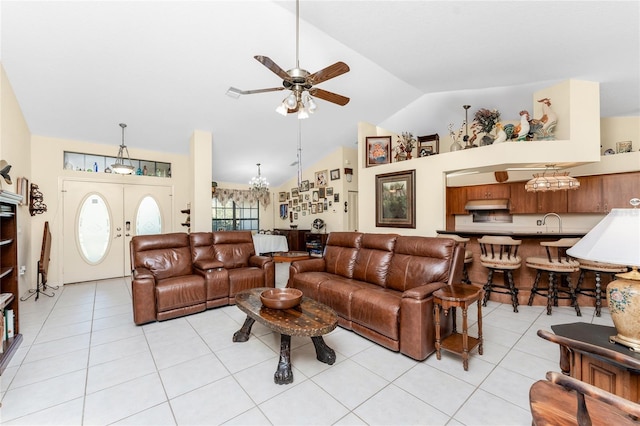 tiled living room featuring french doors, sink, ceiling fan with notable chandelier, and vaulted ceiling